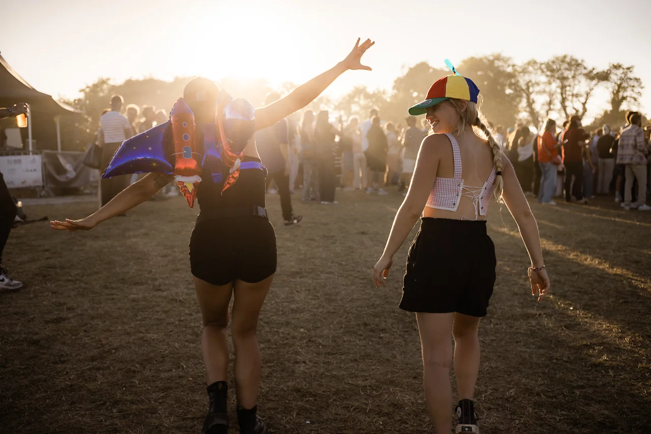 Festivalier soufflant des bulles dans la lumière dorée du Flyin'Festival
