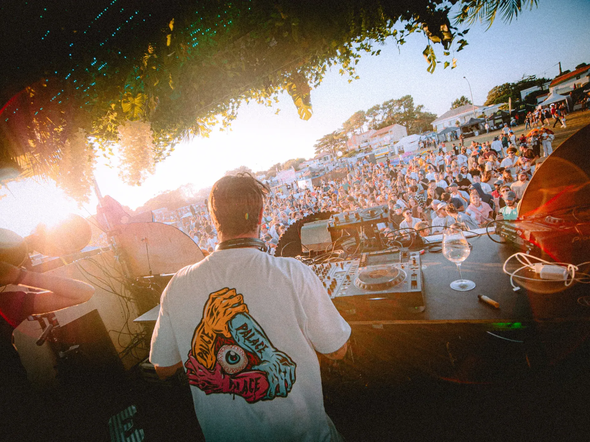 Vue depuis la scène du DJ face à la foule et au coucher de soleil du Flyin'Festival